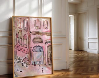 May include: A framed watercolor painting of a pink building with the text "Milly's" on a red awning. The artwork depicts a street scene with figures, tables, and an umbrella. The frame is a light brown color.