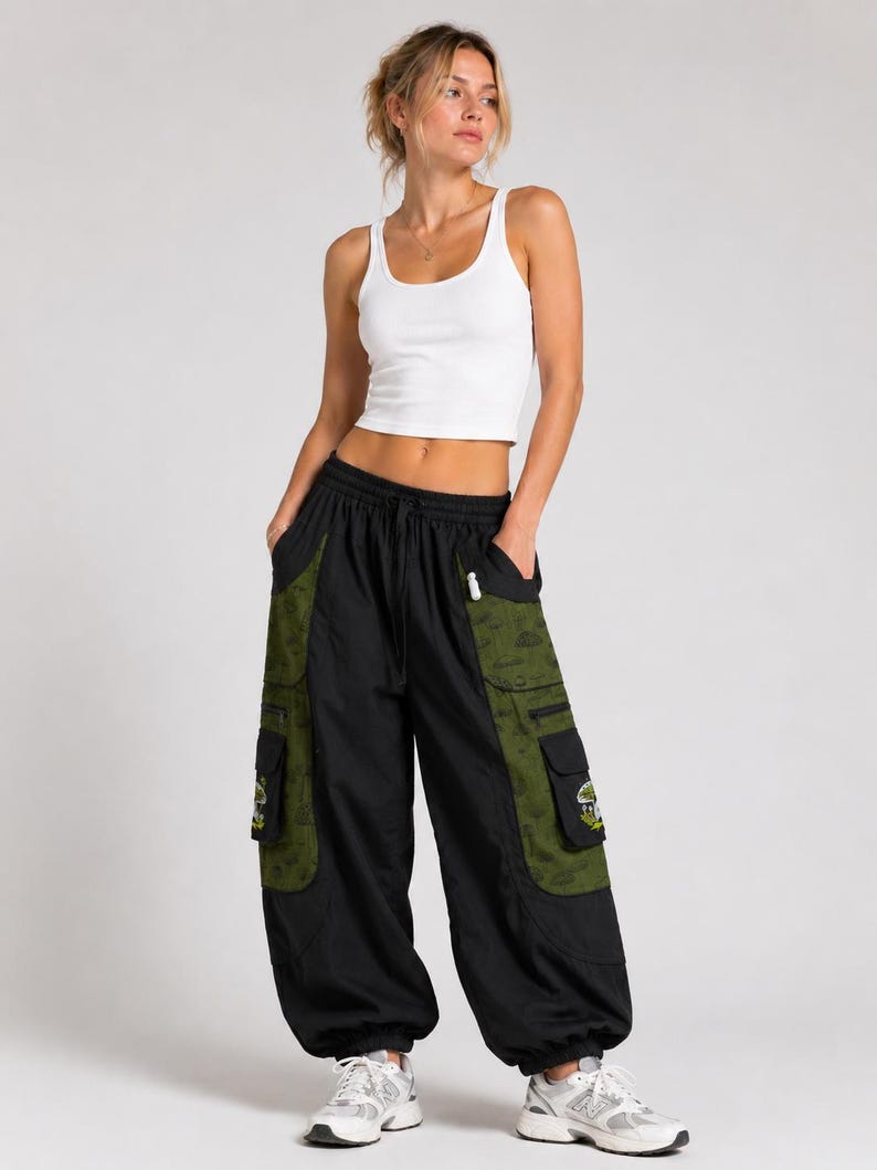 Puede incluir: Una camiseta de tirantes blanca acanalada combinada con pantalones cargo negros con paneles laterales de color verde oliva. Los pantalones incluyen bolsillos grandes con parches de hongos, cintura con cord&oacute;n y pu&ntilde;os el&aacute;sticos.