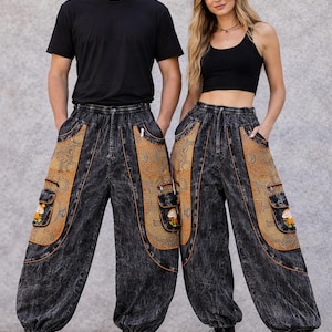 May include: Two people wearing matching black acid wash trousers with large, decorative pockets. The pockets have a tan and orange patterned design with a small floral motif. Both are wearing black tops and boots.
