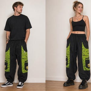 Puede incluir: Pantalones cargo negros con grandes paneles laterales de color verde lima con estampado y m&uacute;ltiples bolsillos. Los pantalones tienen una cintura el&aacute;stica con cord&oacute;n y pu&ntilde;os el&aacute;sticos en los tobillos. Cada bolsillo lateral muestra un peque&ntilde;o parche gr&aacute;fico.