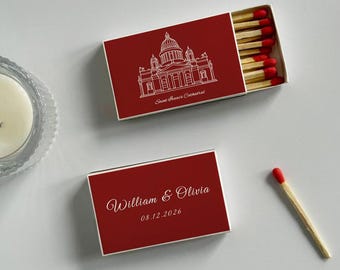 May include: Two red matchboxes with white text and illustrations. One box features a cathedral drawing and the text "Saint Isaac's Cathedral." The other box has the names "William & Olivia" and the date "08.12.2026."