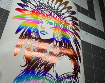 May include: A holographic vinyl decal featuring a detailed illustration of a person wearing a large, elaborate feathered headdress. The design displays a vibrant rainbow color shift across the surface, depicting facial features and jewelry.