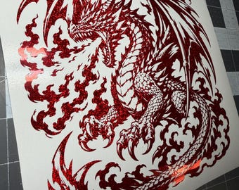 May include: A red glitter vinyl decal featuring a detailed dragon in a dynamic pose, breathing fire. The dragon has sharp scales, large wings, and a long tail, all rendered in a sparkling red finish against a plain white backing sheet.
