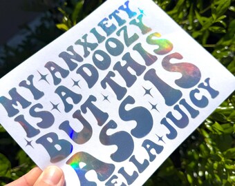 May include: A square white sticker featuring holographic, reflective lettering that reads: MY ANXIETY IS A DOOZY BUT THIS ASS IS HELLA JUICY. The text is arranged in a wavy, retro-inspired font and is accented with small, four-pointed star icons.