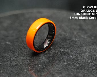 Handgefertigter Ring mit leuchtendem Orange-Glow-In-The-Dark-Design in Orange auf Schwarz