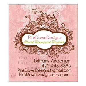 May include: PinkDawnDesigns business card with a pink background and brown floral design. The text reads "PinkDawnDesigns Altered Repurposed Recycled" and includes contact information for Brittany Anderson.
