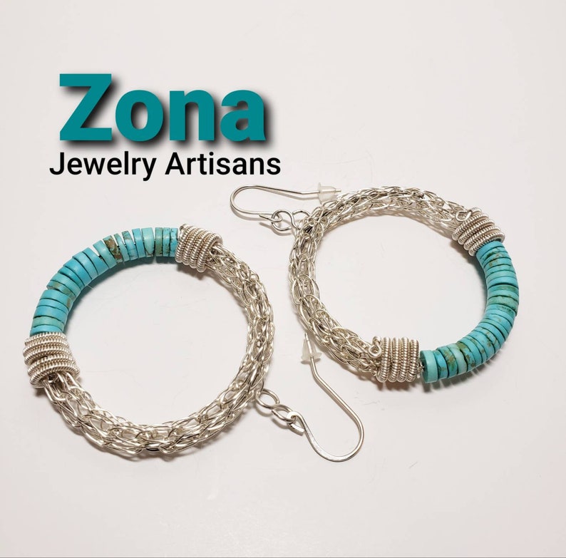 May include: A pair of silver hoop earrings with turquoise stones. The earrings are made of a silver chain and have a turquoise stone design. The earrings are called "Zona Jewelry Artisans".
