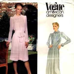 Op de afbeelding: Een Vogue American Designers naaipatroon-envelop voor een Albert Nipon jurk, nummer 2641. De hoes bevat een foto van een lichtroze jurk met lange mouwen, een rucheskraag, ruches aan de mouwen en een ceintuur, naast een mode-illustratie.