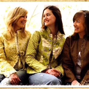 Puede incluir: Tres mujeres con diferentes chaquetas. La mujer de la izquierda lleva una chaqueta amarilla con flores, la mujer del centro lleva una chaqueta verde con flores y la mujer de la derecha lleva una chaqueta de cuero marrón.