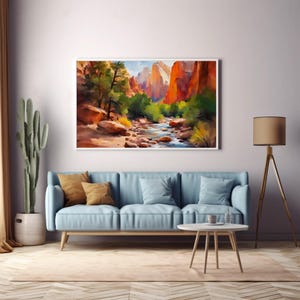 May include: A framed watercolor painting depicts a canyon landscape with red rock formations, a flowing river, and green trees. The artwork hangs above a light blue sofa with throw pillows. A cactus and a floor lamp are also in the room.