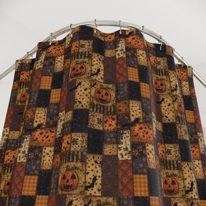 May include: A shower curtain featuring a patchwork design with alternating rectangular blocks in shades of orange, black, and tan. The pattern includes illustrations of jack-o'-lanterns, flying bats, stars, and plaid textures, all suspended from a metal rod.