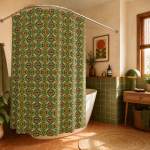 May include: A green and orange patterned shower curtain hangs in a bathroom. The curtain has a repeating floral design. The bathroom has green tile, a wooden side table, and a round jute rug. A framed picture hangs on the wall.