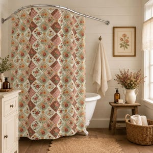 May include: A floral patchwork shower curtain in a bathroom setting. The curtain features a diamond pattern with floral and gingham squares in shades of red, cream, and green. The bathroom has a white tub, wooden stool, and a framed floral print.