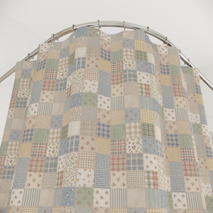 May include: A patchwork shower curtain with a variety of fabric patterns in pastel colors. The curtain features squares of floral, plaid, and striped designs in shades of blue, green, beige, and red. It hangs from a curved, silver-colored shower rod.