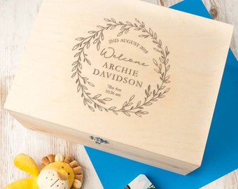 May include: A light wood keepsake box with a personalised inscription. The inscription reads "2nd August 2018 Welcome Archie Davidson 7lbs 4oz 10:36 am" inside a wreath of leaves.