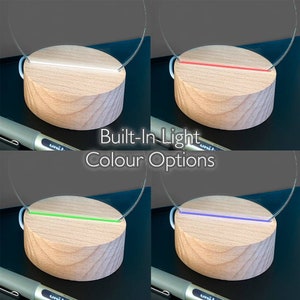 May include: A wooden base with a built-in light, showcasing color options: white, red, green, and blue. The light is integrated into a clear, curved acrylic element. The text "Built-In Light Colour Options" is displayed.