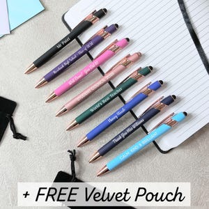 Puede incluir: Una variedad de bolígrafos personalizados en varios colores, incluyendo negro, morado, rosa, verde, azul y celeste. Cada bolígrafo tiene detalles en oro rosa y está grabado con textos como "Mr Patel" y "Well Done! You Did It!". También se incluye una funda de terciopelo negro.