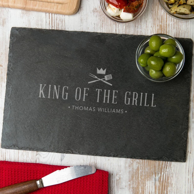 a rectangular cutting board made from Eco-Friendly natural material engrave the phrase "King of the Grill", name is the best gift for Husband