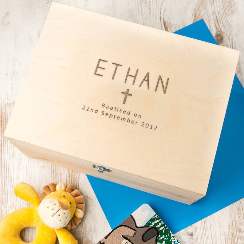 May include: A wooden keepsake box with a hinged lid and a brass latch. The box is engraved with the name "ETHAN" and the date "Baptised on 22nd September 2017".