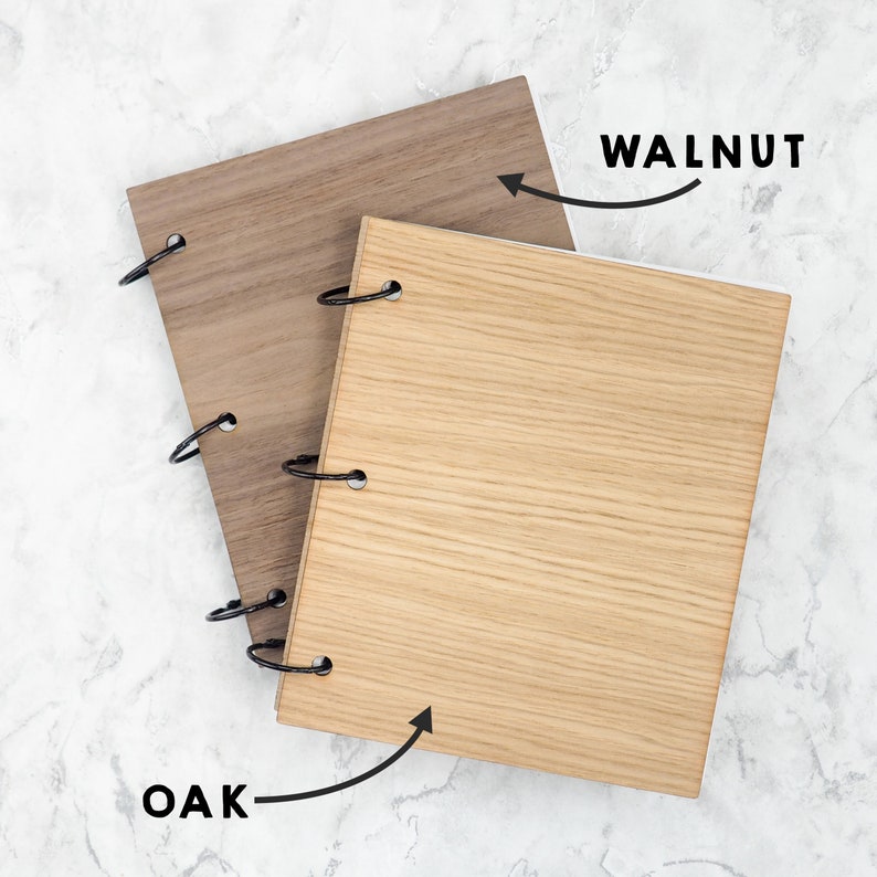 Puede incluir: Dos carpetas rectangulares de madera con anillas de metal negro. La carpeta superior es de color marr&oacute;n oscuro con la etiqueta WALNUT y una flecha, la inferior es de color tostado claro con la etiqueta OAK y una flecha hacia la veta.