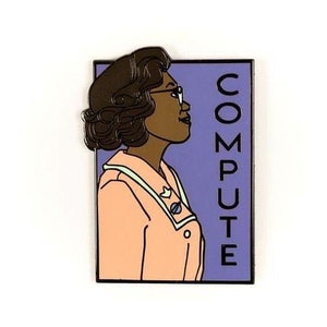 Peut inclure: Une épingle en émail violette et noire représentant une femme de dessin animé avec des lunettes et le mot "COMPUTE" écrit verticalement.