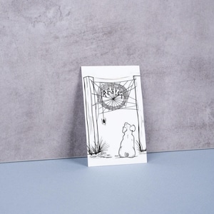 Puede incluir: Ilustración en blanco y negro sobre una tarjeta blanca. La obra representa a un perro mirando una telaraña con la palabra "RESIST" en el centro. La tarjeta está apoyada contra una pared gris sobre una superficie azul.