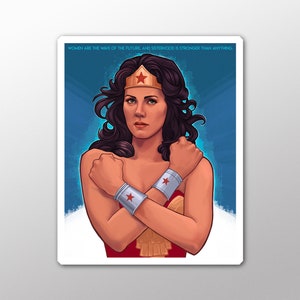 Könnte beinhalten: Eine digitale Illustration von Wonder Woman mit verschränkten Armen. Sie trägt ihr ikonisches rot-blau-goldenes Kostüm mit einem roten Stern auf der Stirn. Der Hintergrund ist ein blauer Farbverlauf. Der Text "WOMEN ARE THE WAVE OF THE FUTURE, AND SISTERHOOD IS STRONGER THAN ANYTHING." befindet sich oben im Bild.