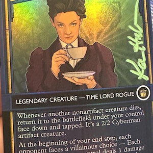 Puede incluir: Carta coleccionable con "Missy" de Doctor Who, una Criatura Legendaria Time Lord Rogue. La carta tiene un retrato de Missy sosteniendo una taza de té, con texto que describe la mecánica del juego y una firma. La carta es 4/5.