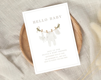 May include: A white baby shower invitation with a watercolor illustration of baby clothes hanging on a clothesline. The text reads "Hello Baby" and includes details about the shower, including the date, time, location, and RSVP information.