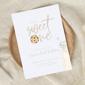 May include: A light blue invitation card with brown text that reads "He's a sweet one" with a chocolate chip cookie illustration. The text also includes "Please join us for Liam's First Birthday, September 5th at 3pm, At 123 anywhere st..., rsvp to 123-456-7890".