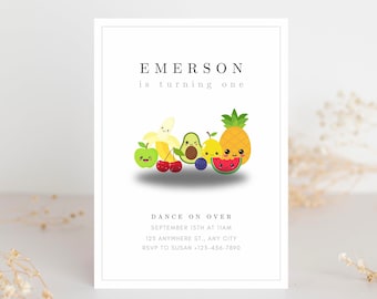 May include: White invitation card with the text "EMERSON is turning one". The card features a cartoon illustration of smiling fruits, including a banana, apple, cherries, avocado, pear, blueberries, pineapple, and watermelon. The invitation also includes event details.