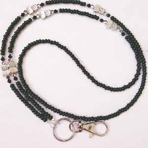 May include: Black beaded lanyard with silver cat charms and a silver swivel clasp.