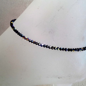 May include: A delicate black anklet made with iridescent crystal beads.