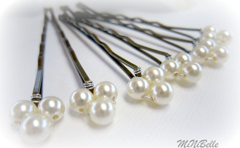 May include: Set of six silver hair pins with three white pearl beads on each pin.