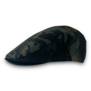 Peut inclure: Une casquette plate de couleur camouflage noir et vert avec une visière noire.