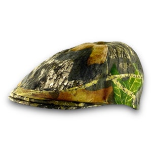 Puede incluir: Gorra plana de camuflaje en tonos verdes, marrones y beiges. El sombrero tiene una forma cl&aacute;sica y redondeada con una peque&ntilde;a visera r&iacute;gida. La tela presenta un patr&oacute;n detallado de bosque, adecuado para actividades al aire libre o un estilo informal.