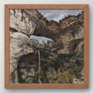 Può includere: Dipinto a olio di un arco di roccia naturale con una cascata. L'opera è incorniciata in una cornice di legno marrone chiaro. Il dipinto presenta sfumature di grigio, marrone e verde.