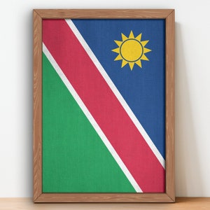Peut inclure: Une impression sur toile encadrée du drapeau de la Namibie. Le drapeau présente une bande diagonale rouge, blanche et bleue avec un soleil jaune dans le coin supérieur droit.