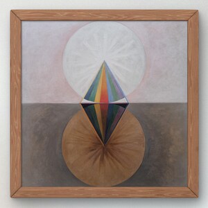 Peut inclure: Une peinture carrée dans un cadre en bois clair représentant une forme de losange centrale divisée en une moitié supérieure avec des segments verticaux arc-en-ciel et une moitié inférieure aux tons sombres et sourds. Un grand cercle blanc se trouve derrière le haut.