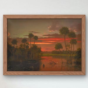 Peut inclure: Une peinture encadrée représentant un coucher de soleil sur un paysage marécageux. Le ciel est d'un orange et d'un rouge vifs, avec des nuages au loin. Des palmiers bordent les rives de l'eau, qui est d'un bleu foncé. La peinture est dans un cadre en bois.