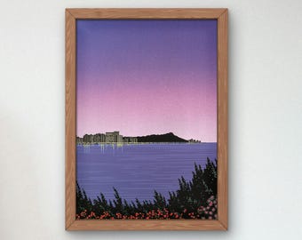 May include: A framed art print depicting a coastal scene at dusk. The artwork features a purple and pink gradient sky, a dark silhouette of a mountain, and a city skyline with illuminated buildings. The foreground shows water and foliage.