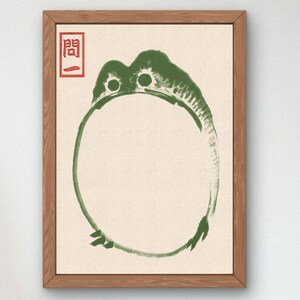 Peut inclure: Une estampe encadrée d'un cercle vert avec un motif de grenouille. Le cercle est dessiné dans un style de coup de pinceau. L'estampe a un tampon rouge avec le caractère chinois "門" dans le coin supérieur gauche.