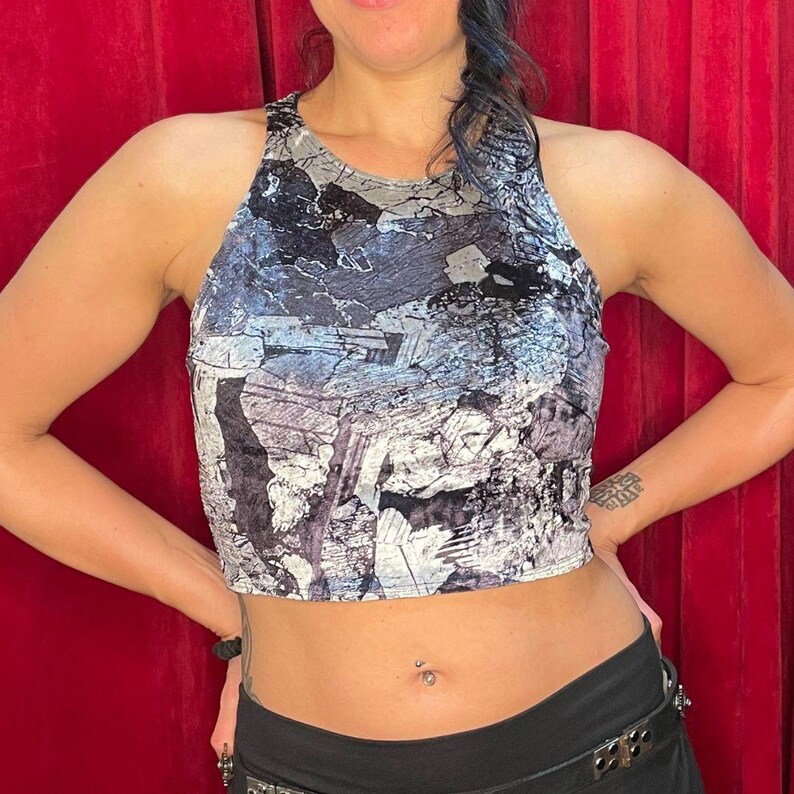 May include: A black and white crop top with a geometric pattern. The top is made of a soft, velvety material.