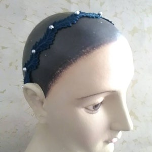 May include: A dark blue headband with a delicate lace design and silver beads.