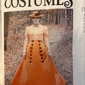May include: McCall's costume pattern featuring a vintage orange and white striped dress with a matching hat. The pattern includes a long skirt with large black buttons and a high-collared blouse. The text "COSTUMES" is prominently displayed.