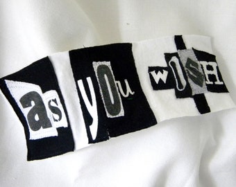 Puede incluir: Pancarta de tela en blanco y negro con las palabras "as you wish" en estilo patchwork.