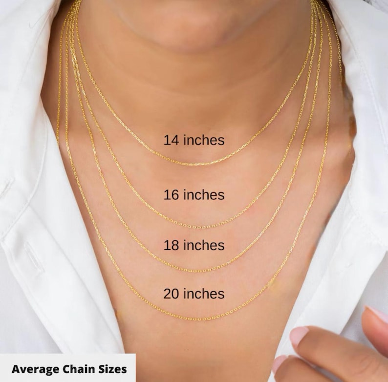 May include: A close-up of a person wearing four gold-colored necklaces of varying lengths: 14, 16, 18, and 20 inches. The text "Average Chain Sizes" is at the bottom of the image. The person is wearing a white shirt.