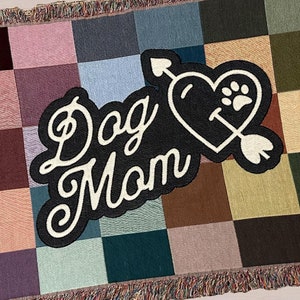 Front of colorful woven cotton Dog Mom throw blanket featuring retro checkerboard design.