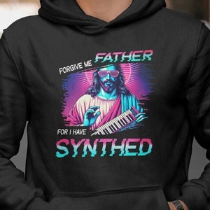 May include: Black hoodie with a graphic of Jesus playing a keyboard with the text "Forgive me Father for I have Synthed".