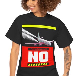 Puede incluir: Camiseta negra con un gráfico de un avión estrellándose contra una señal roja que dice "NO" con el texto "#cliffdivingessati" encima. La señal tiene cinta de precaución amarilla.